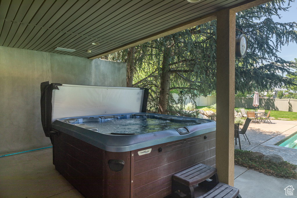 View of patio / terrace with a hot tub and outdoor dining area