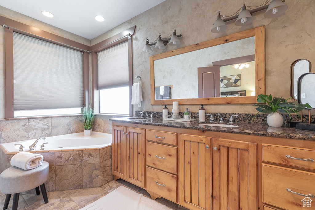 Bathroom featuring double vanity and a bath