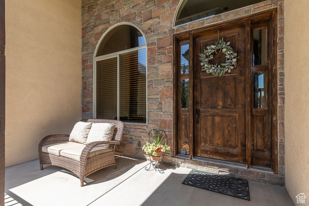 Entrance to property featuring stone siding and stucco siding