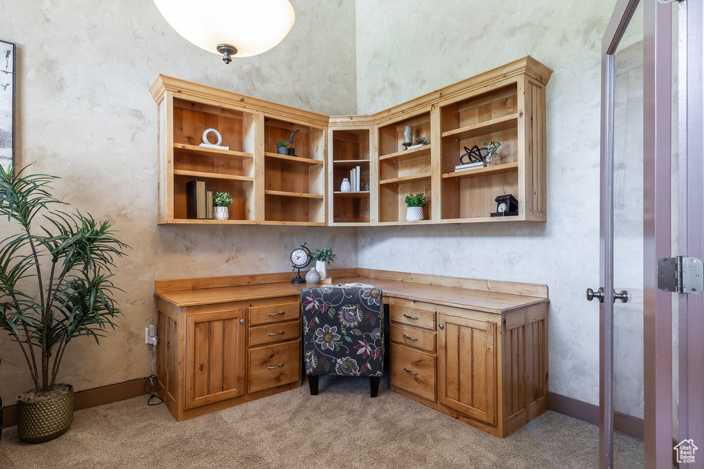 Home office with built in study area and light carpet