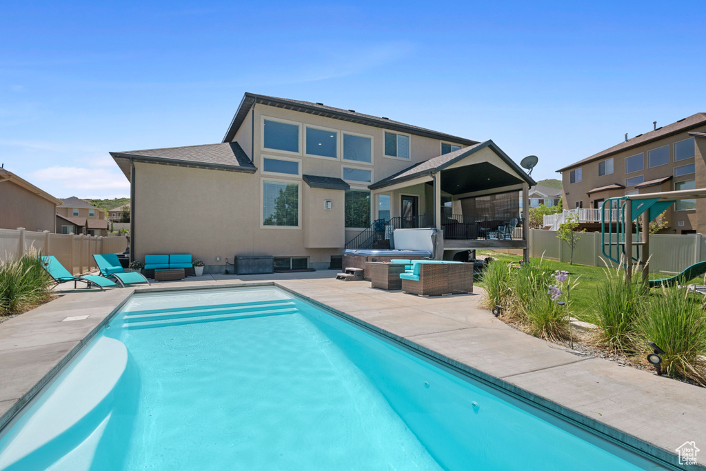 Back of house featuring an outdoor living space, a patio, and stucco siding