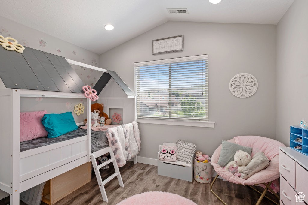 Bedroom with wood finished floors, lofted ceiling, baseboards, and recessed lighting