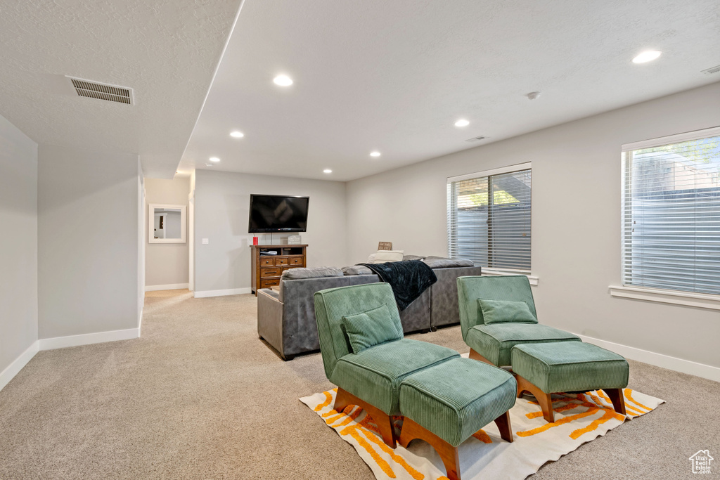 Living room with light colored carpet, baseboards, and recessed lighting