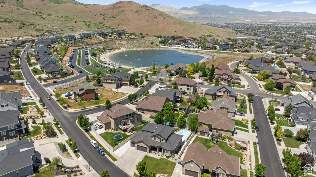 Aerial view of property and surrounding area featuring nearby suburban area and a water and mountain view