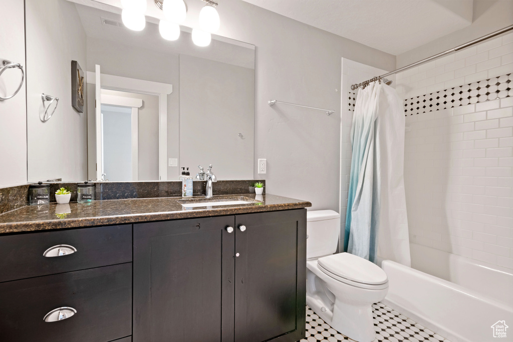 Full bath with toilet, vanity, shower / tub combo with curtain, and tile patterned floors