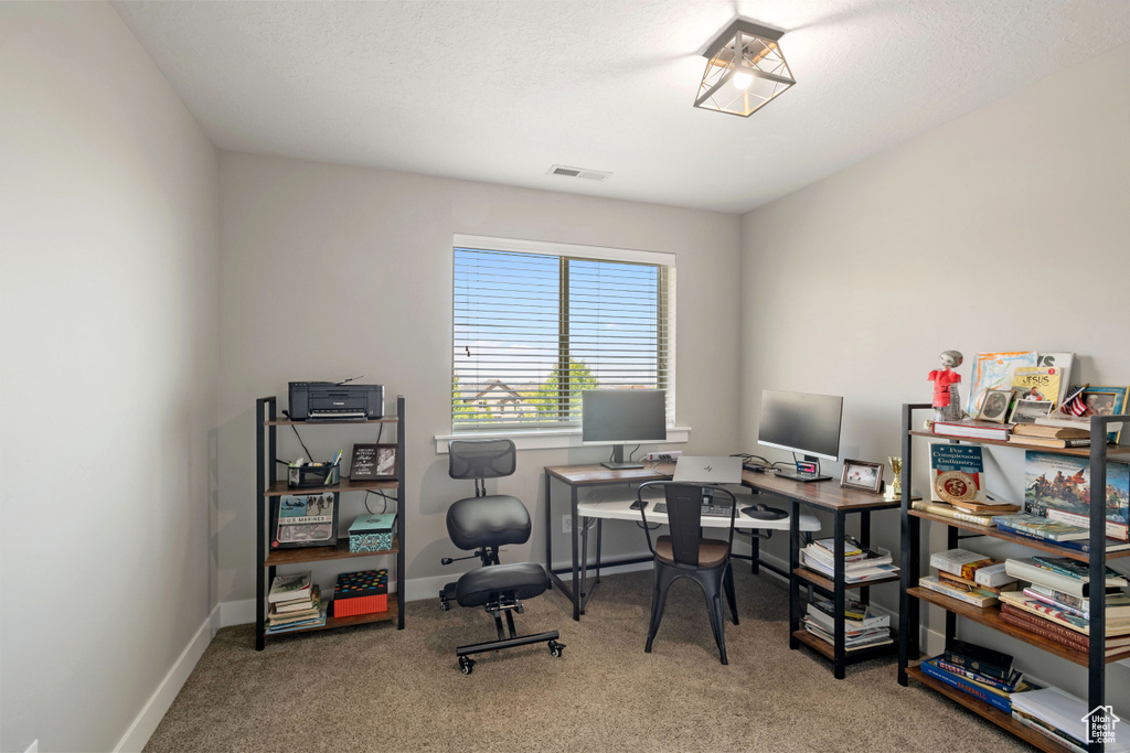 Carpeted office space with baseboards