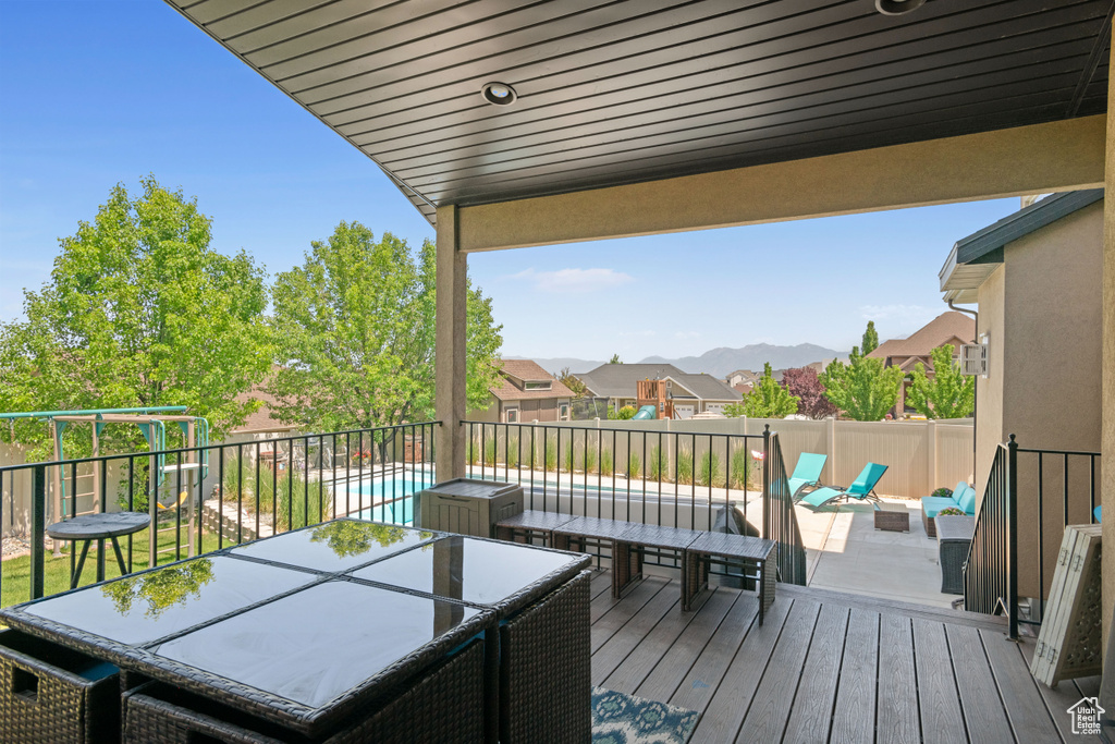 Wooden terrace featuring an outdoor hangout area, a fenced backyard, a mountain view, and outdoor dining area