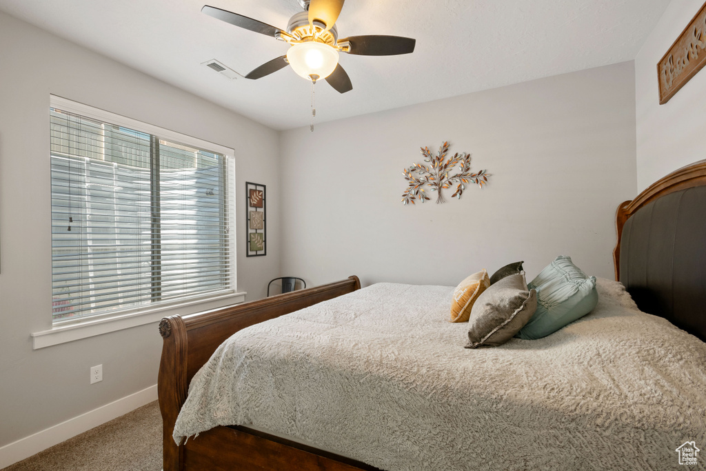 Carpeted bedroom featuring baseboards and a ceiling fan