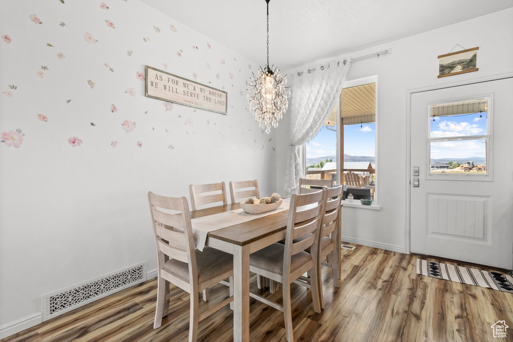 Dining space with light wood finished floors and a chandelier