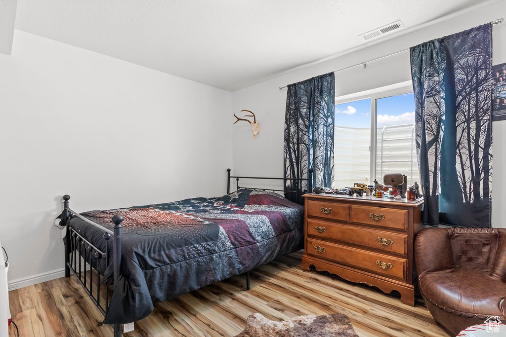 Bedroom with light wood-style floors and baseboards
