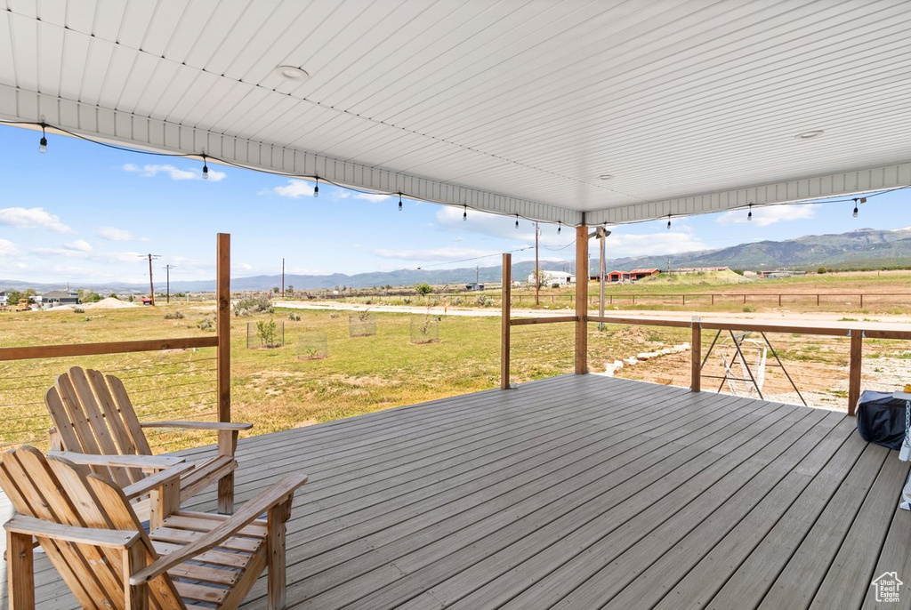 Wooden deck featuring a view of countryside and a mountain view