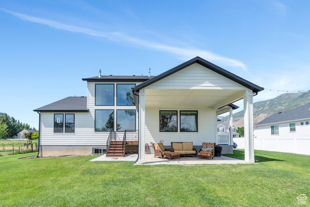 Back of house featuring an outdoor living space, a patio, and a mountain view