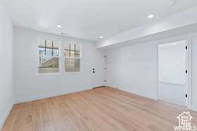 Empty room featuring light wood-type flooring, recessed lighting, and baseboards