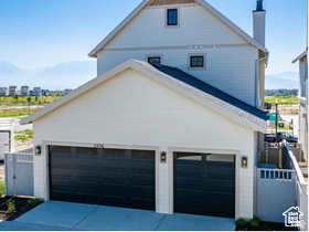 View of property exterior featuring concrete driveway and a chimney