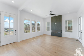 Unfurnished living room featuring plenty of natural light, light wood-type flooring, ceiling fan, a fireplace, and recessed lighting