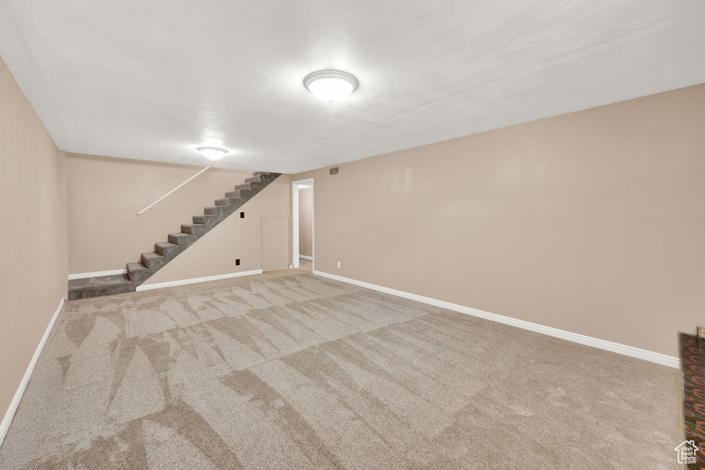 Finished basement featuring carpet, stairway, and baseboards
