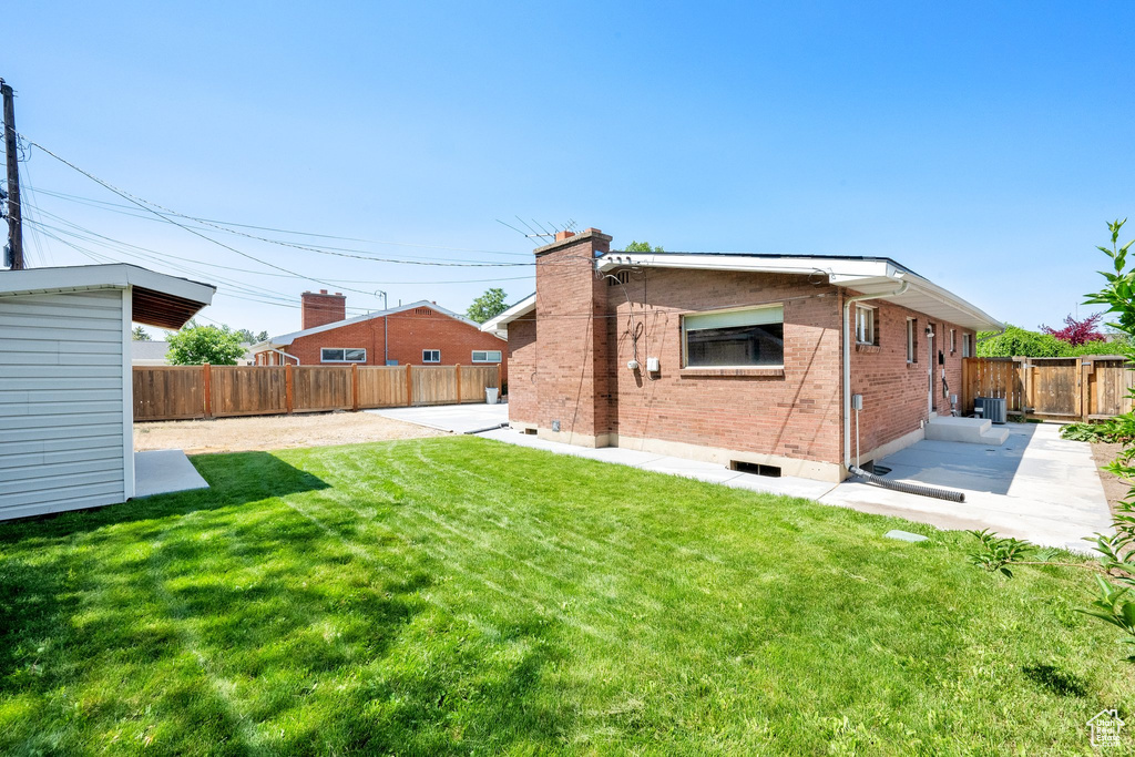 Rear view of property with a patio, brick siding, a chimney, and central air condition unit