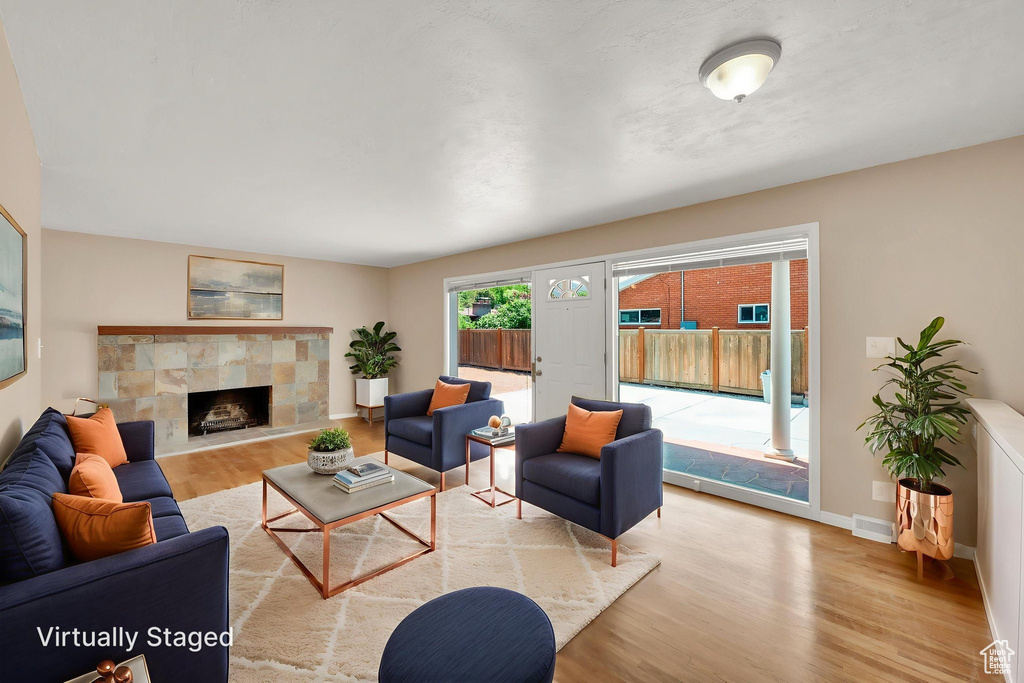 Living room featuring wood finished floors, a fireplace, and baseboards