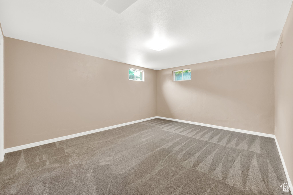 Carpeted empty room with baseboards