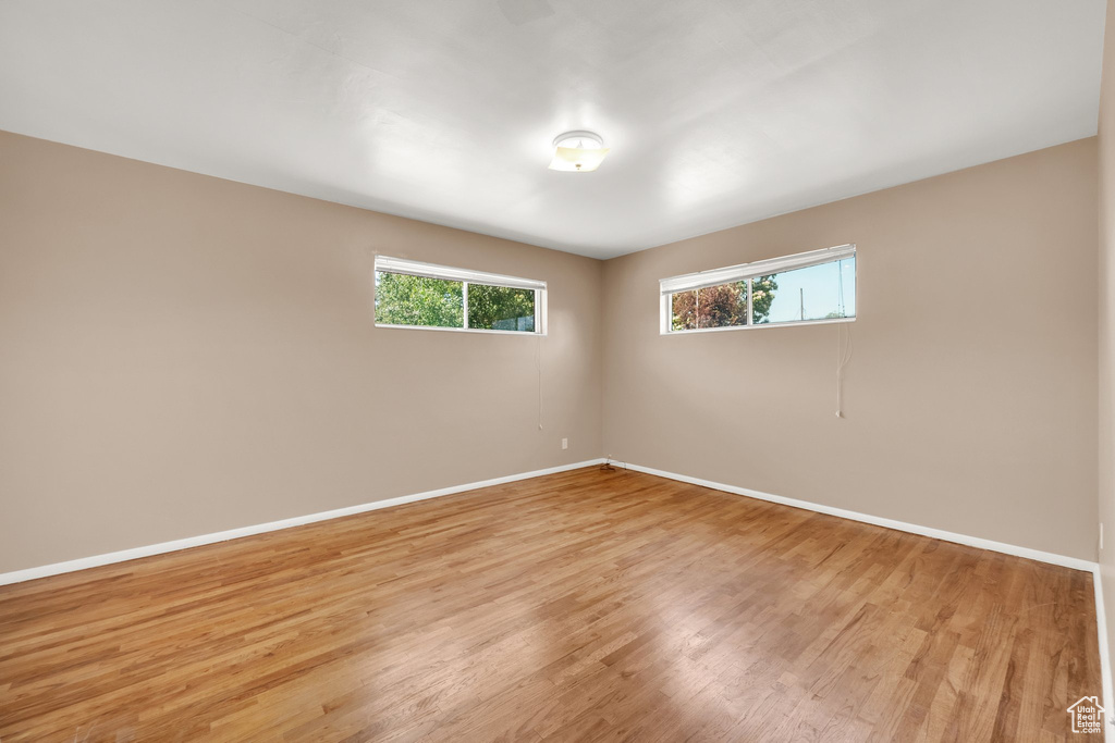Spare room with baseboards and light wood-style flooring