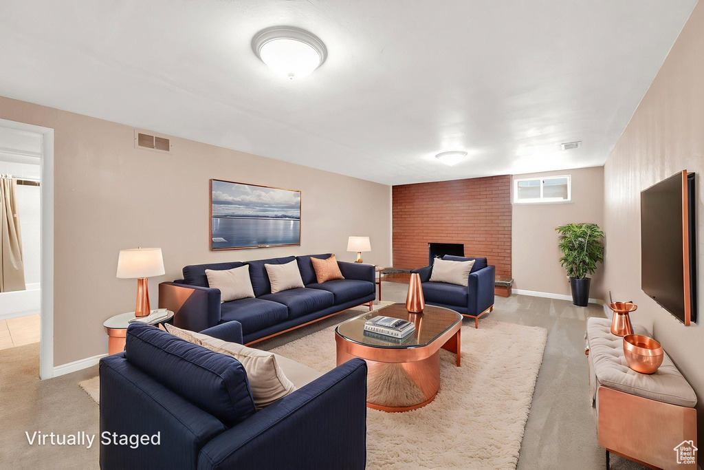 Living room with light carpet, a brick fireplace, and baseboards