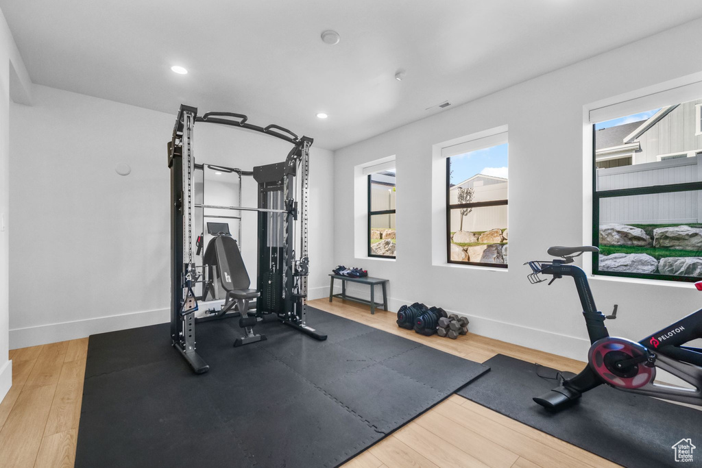 Exercise room featuring baseboards, wood finished floors, and recessed lighting