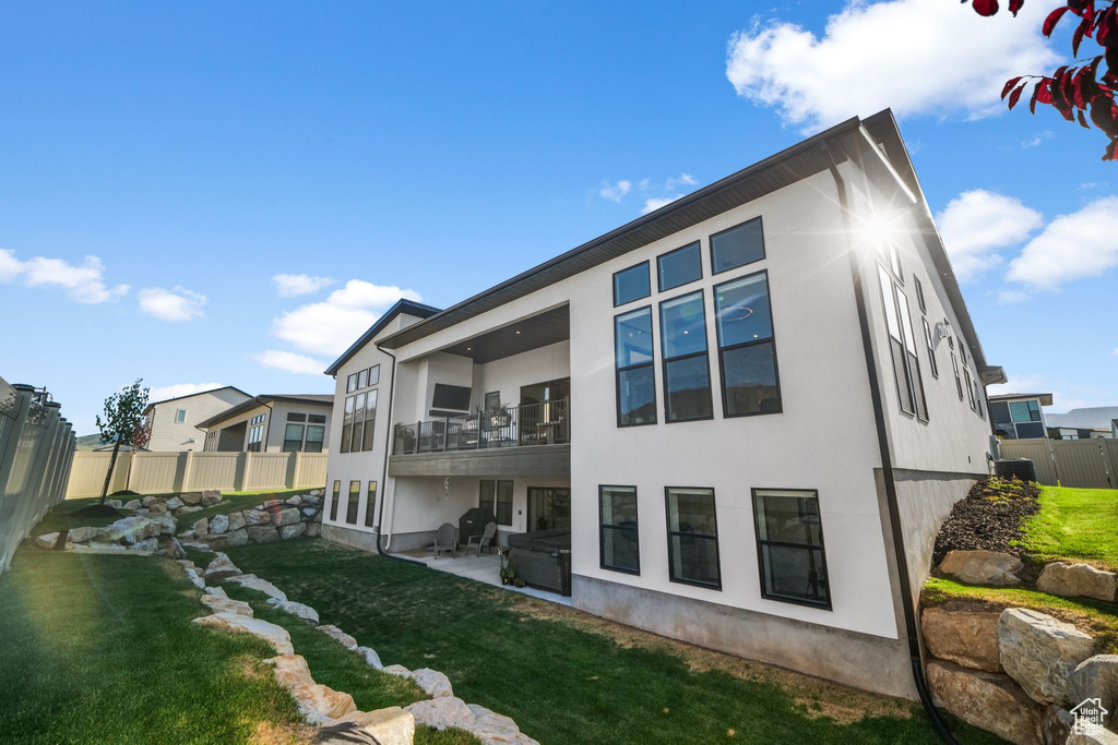Back of property featuring a balcony, stucco siding, and a patio area