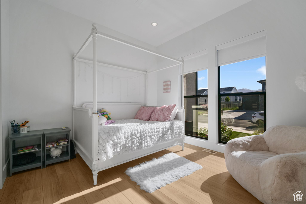 Bedroom with multiple windows, wood finished floors, and recessed lighting