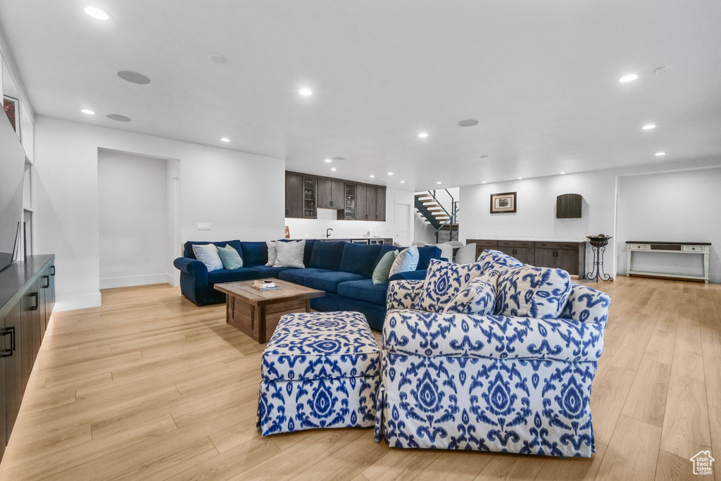 Living room with stairway, recessed lighting, and light wood-style floors