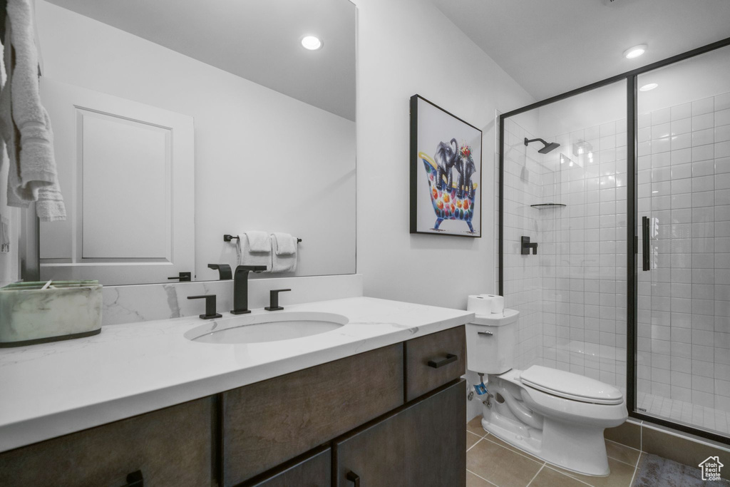 Full bathroom with vanity, toilet, a stall shower, tile patterned floors, and recessed lighting
