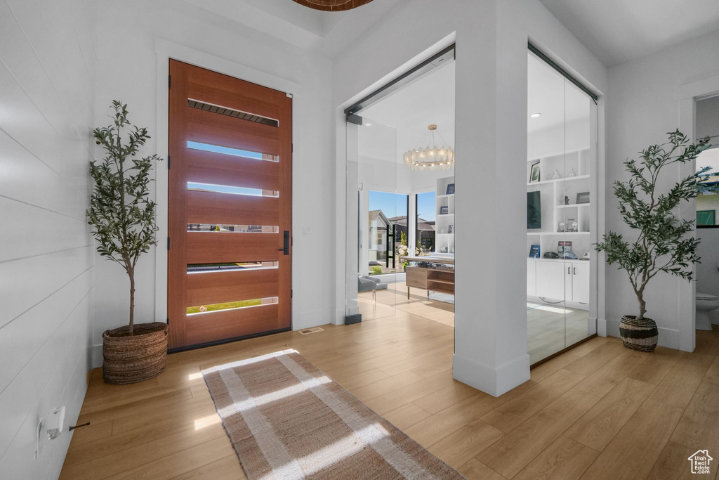 Entryway featuring light wood-type flooring and a chandelier