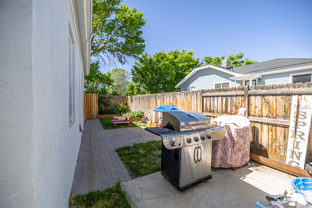 Fenced backyard with a grill and a patio