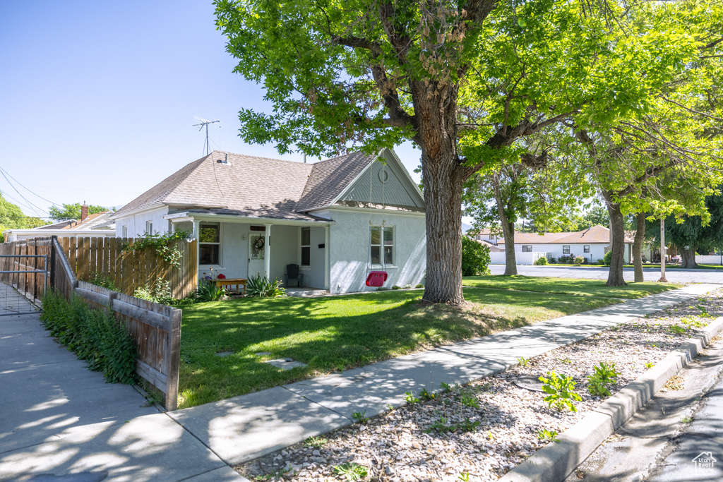 View of front of house with stucco siding and a shingled roof
