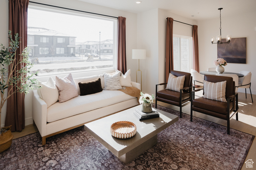 Living room featuring a chandelier, plenty of natural light, wood finished floors, recessed lighting, and baseboards