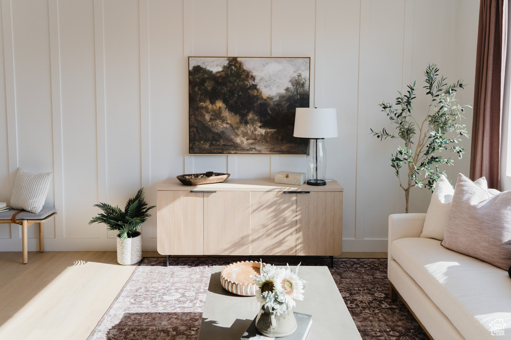 Living area with a decorative wall and wood finished floors