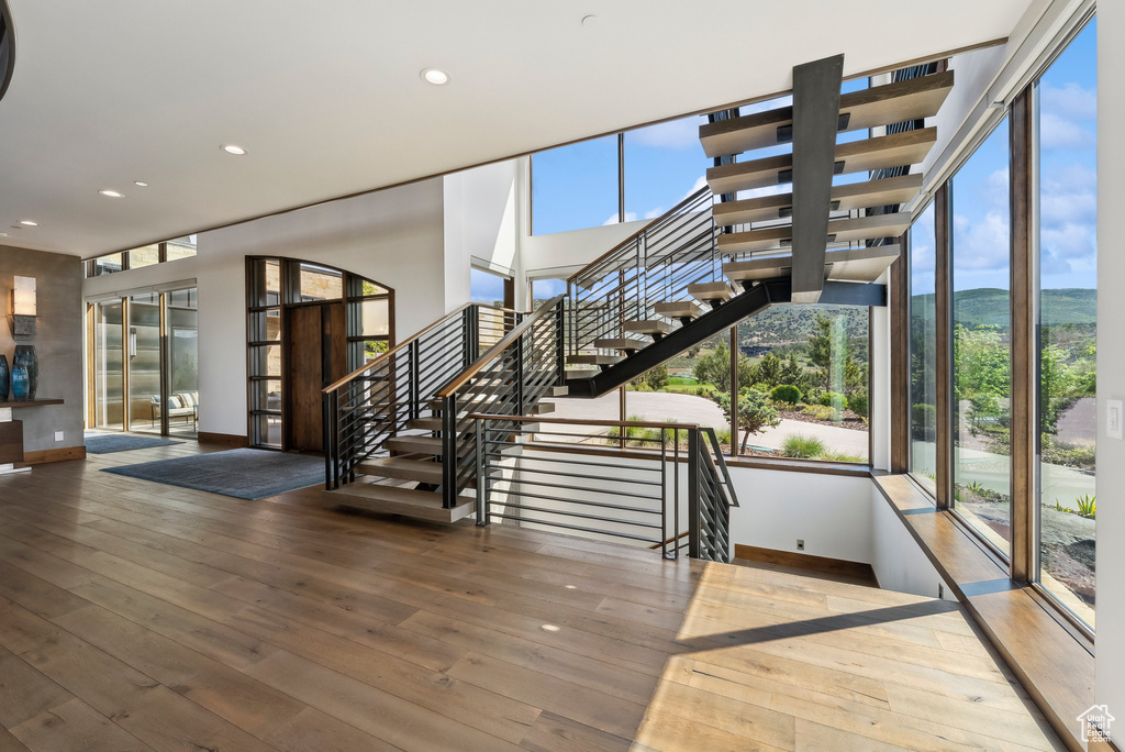 Staircase featuring baseboards, hardwood / wood-style flooring, recessed lighting, french doors, and a mountain view