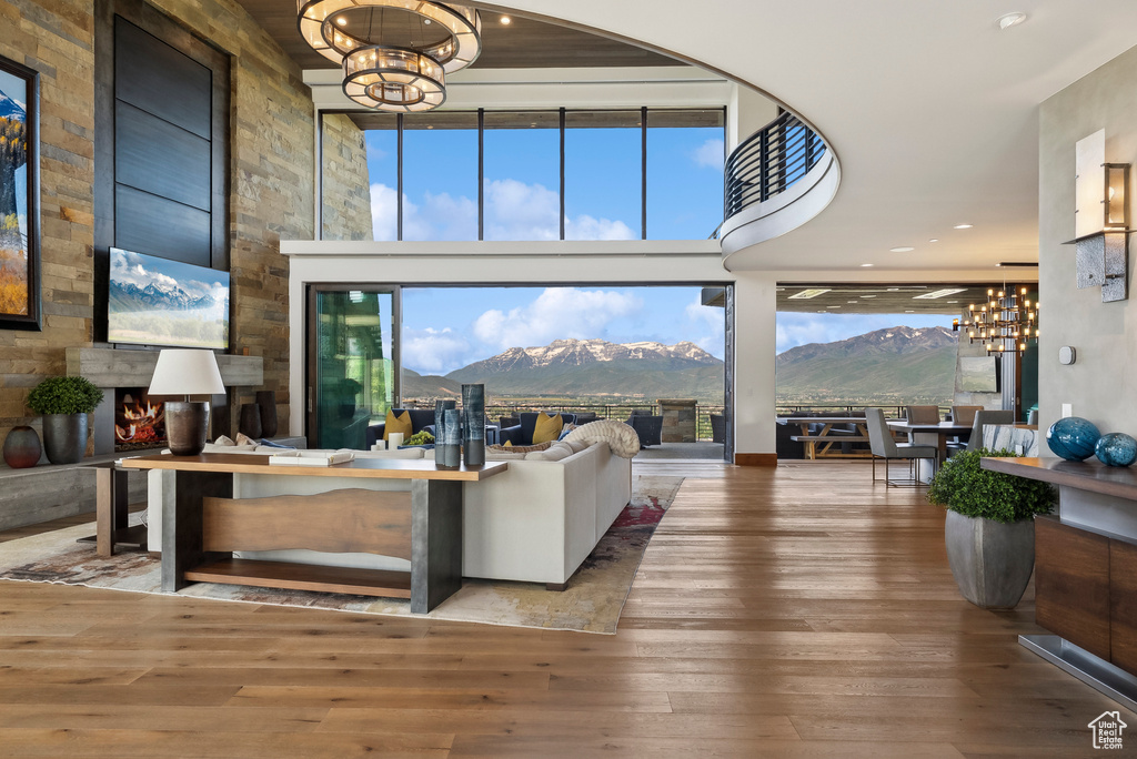 Living area featuring a chandelier, a mountain view, hardwood / wood-style flooring, and a towering ceiling