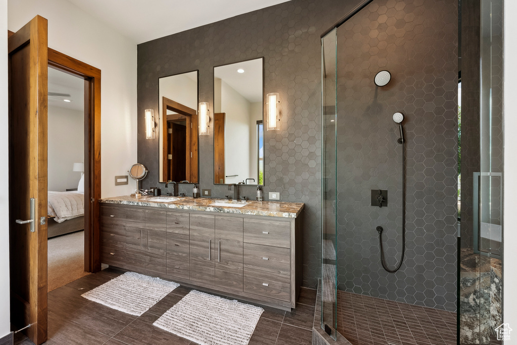Full bathroom featuring a shower stall, double vanity, and ensuite bath