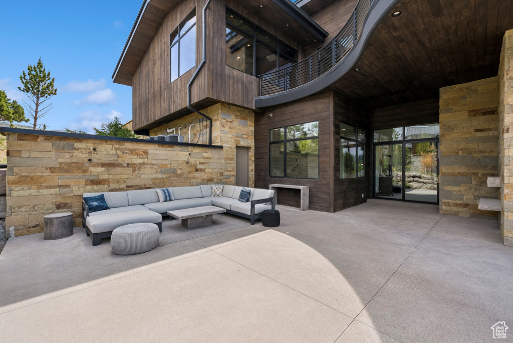 View of patio / terrace featuring a balcony and an outdoor living space with a fireplace
