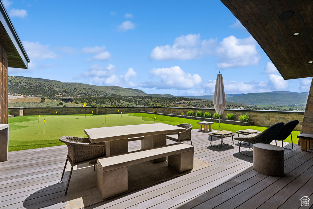 Wooden deck with a putting area and a mountain view