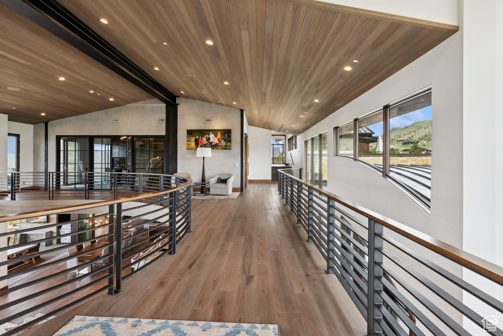 Hallway with vaulted ceiling, wood ceiling, wood finished floors, an upstairs landing, and recessed lighting