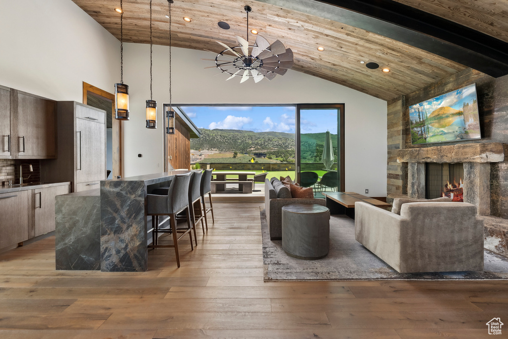 Living room featuring high vaulted ceiling, recessed lighting, light wood finished floors, and wood ceiling with exposed beams