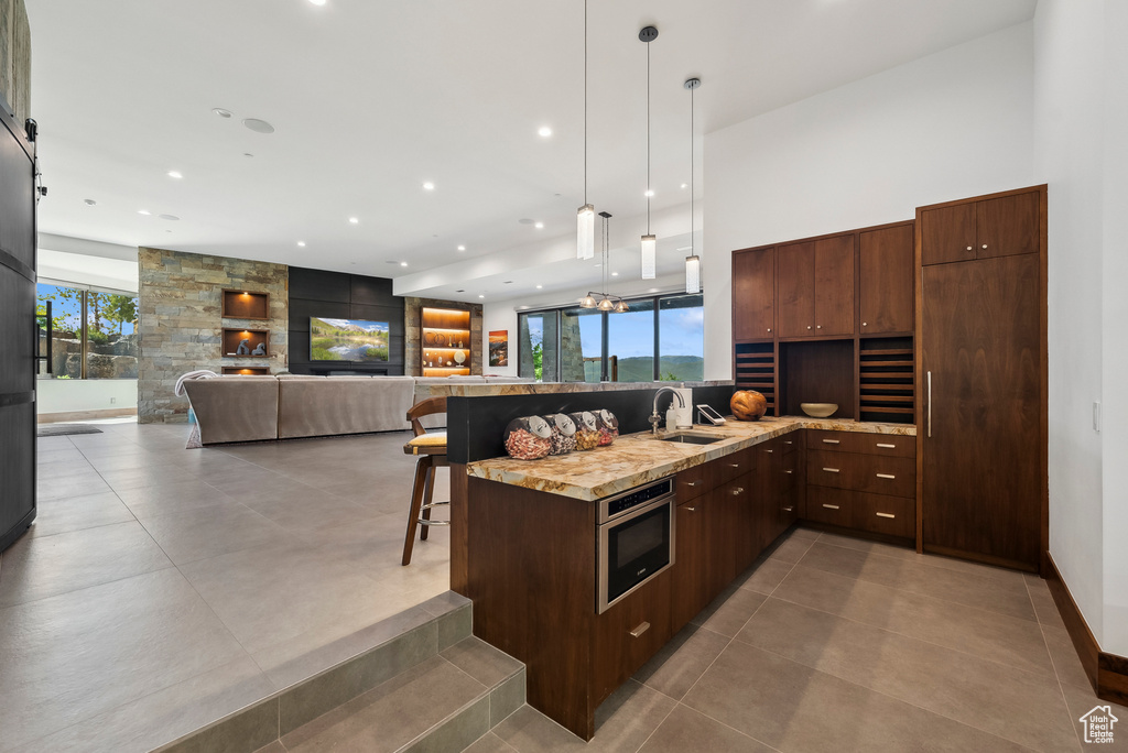 Kitchen featuring a sink, a breakfast bar, pendant lighting, recessed lighting, and plenty of natural light