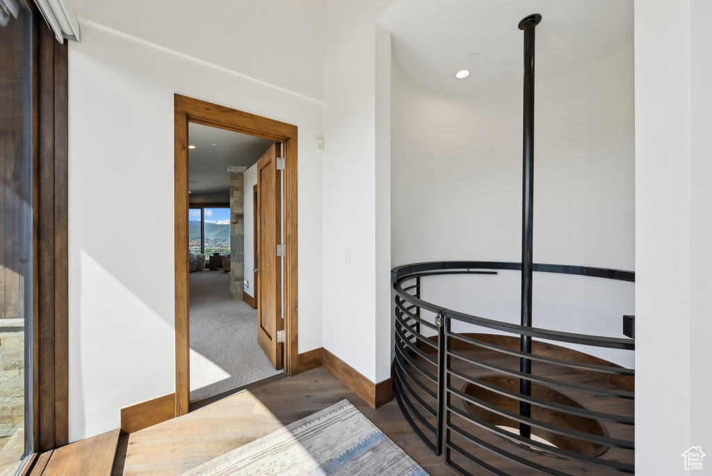 Hallway featuring baseboards, wood finished floors, and recessed lighting