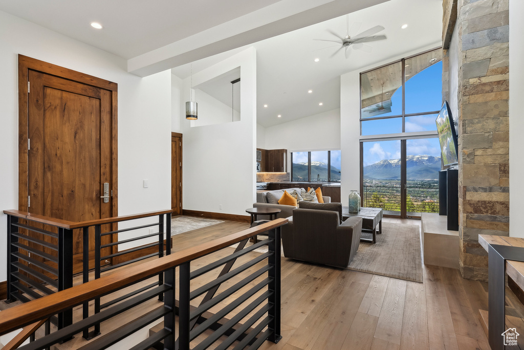 Living room featuring hardwood / wood-style flooring, high vaulted ceiling, ceiling fan, and recessed lighting