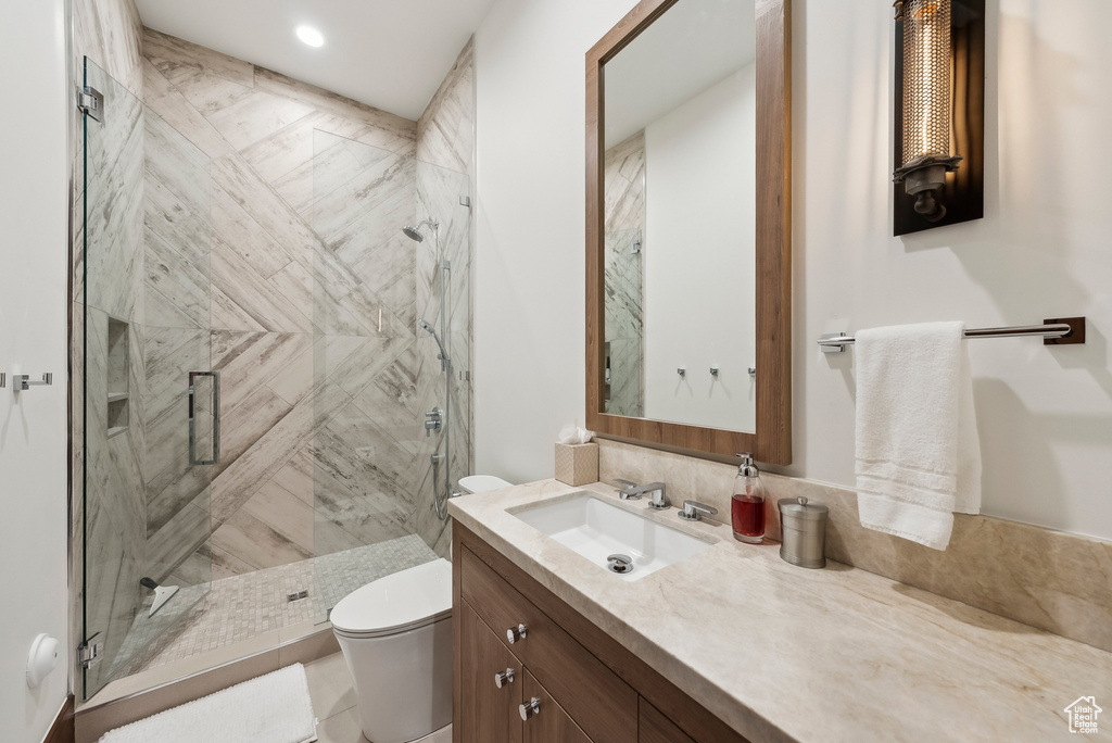 Bathroom with toilet, vanity, and a shower stall