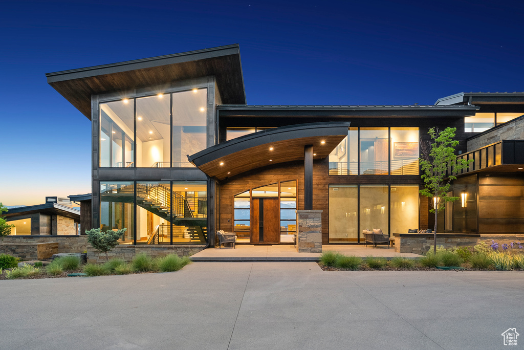 Back of property with stairs, a patio, and a balcony