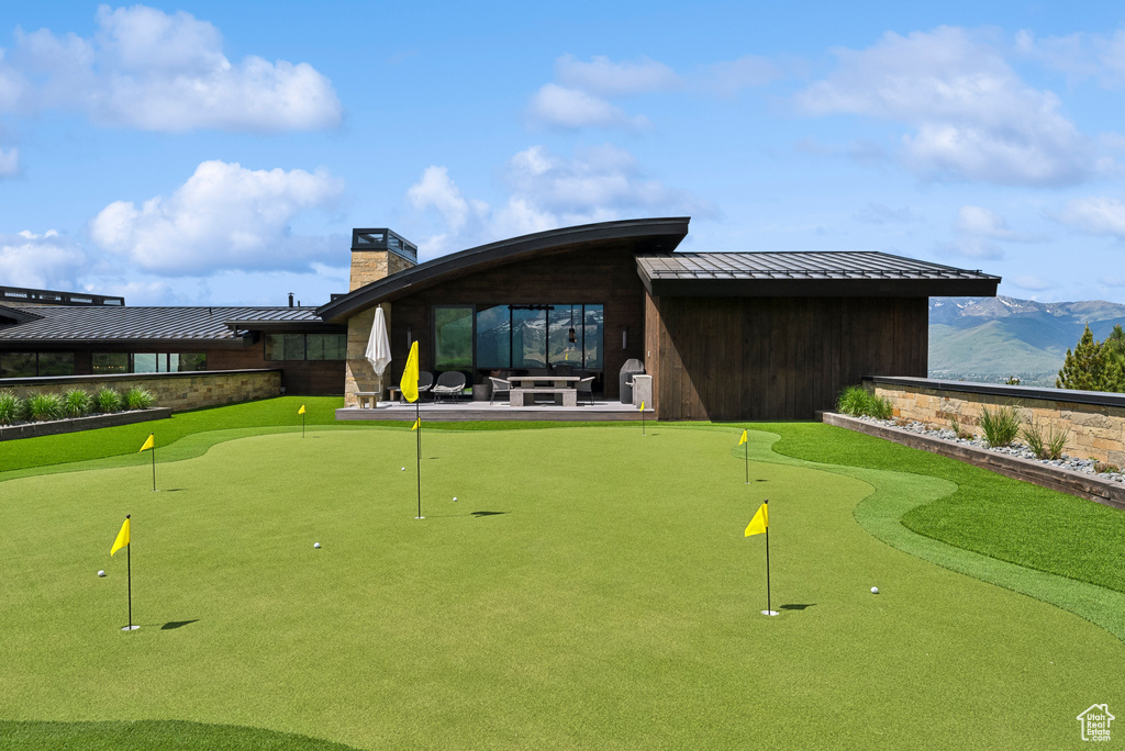 View of home\'s community with a putting green, a patio area, and a mountain view
