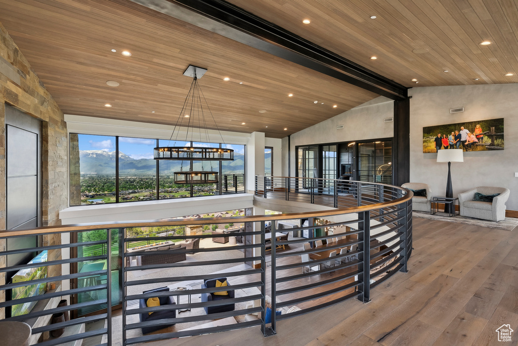 Hallway featuring wooden ceiling, hardwood / wood-style flooring, recessed lighting, an upstairs landing, and a chandelier