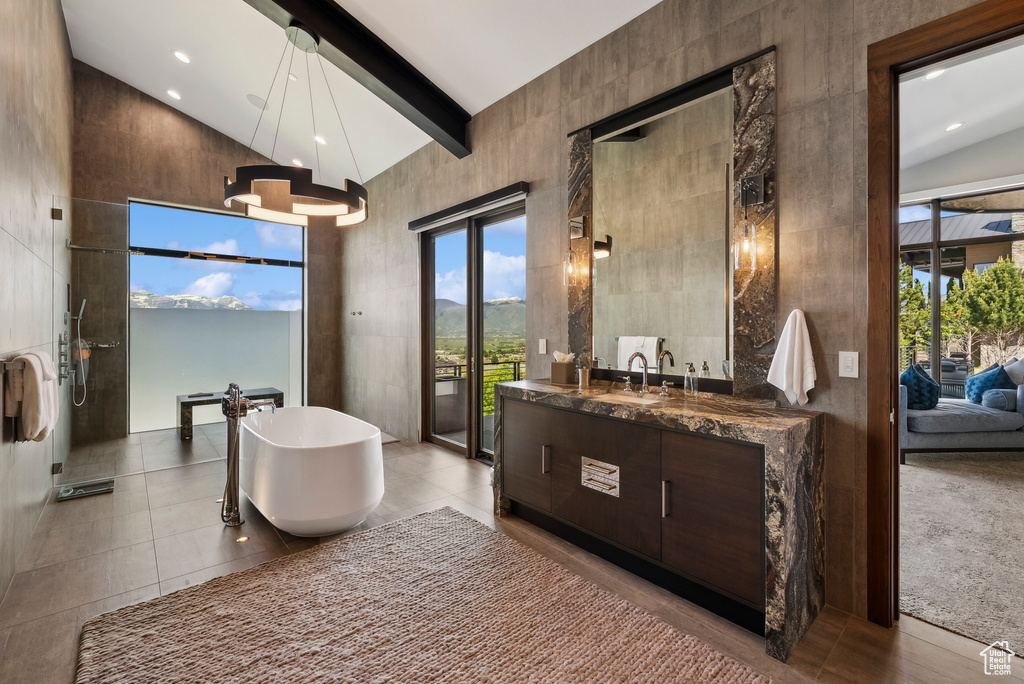 Full bath with high vaulted ceiling, a freestanding tub, vanity, ensuite bath, and beamed ceiling